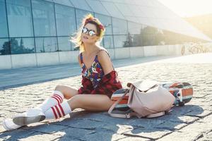 Stylish girl with a skateboard on the street photo