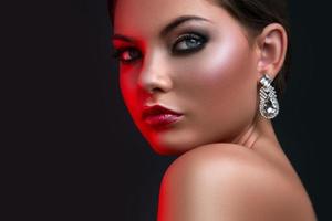 Woman with beautiful earrings in red light photo