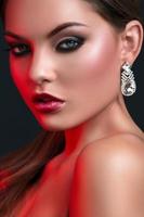 Woman with beautiful earrings in red light photo