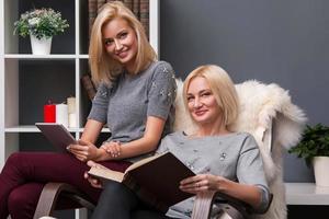 madre e hija adulta leyendo en casa foto