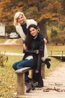 Portrait of two beautiful girls friends in autumn park photo