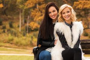 retrato de dos hermosas amigas en el parque de otoño foto