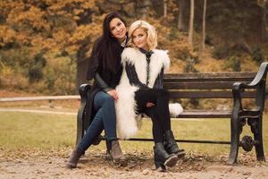 Portrait of two beautiful girls friends in autumn park photo