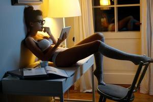 mujer sexy en lencería está usando tableta a altas horas de la noche foto