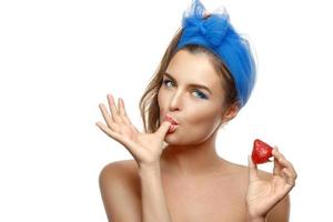 mujer con maquillaje colorido está comiendo fresa foto