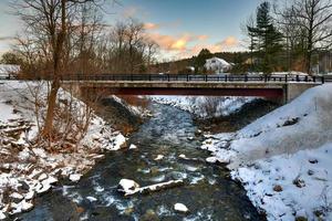 Snowy shores of the Whetstone Brook in West Brattleboro, Vermont in the winter. photo