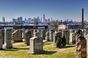 New York City - Feb 23, 2020 -   Calvary Cemetery with Manhattan skyline in New York. Calvary Cemetery is a cemetery in Queens, containing more than 3 million burials. photo