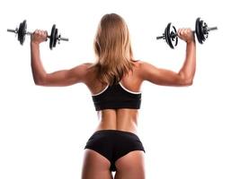 Young and beautiful fitness girl with dumbbells photo