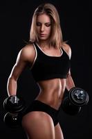 Young and beautiful fitness girl with dumbbells photo