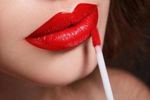 Closeup of red female lips and lipstick photo