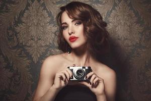 hermosa mujer con una cámara vintage en las manos foto
