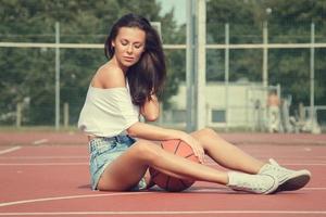 joven mujer sexy con en un patio de baloncesto foto