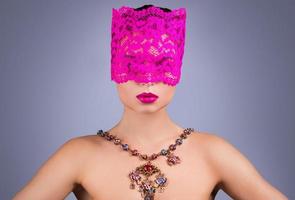 Woman with pink blindfold on her eyes photo