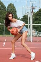 joven mujer sexy con en un patio de baloncesto foto