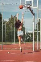 joven mujer sexy con en un patio de baloncesto foto