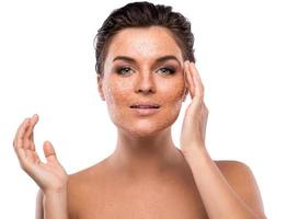 Young beautiful woman with sugar scrub on her face photo