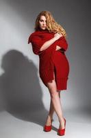 Plus size model wearing lingerie and red knitted coat photo