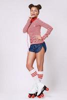 Beautiful woman in the roller-skates and with red headphones photo