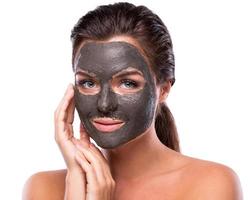 Beautiful woman with a clay or a mud mask on her face photo
