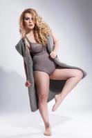 Plus-size model wearing lingerie and grey cardigan photo