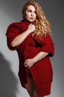 Plus size model wearing lingerie and red knitted coat photo