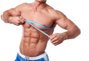 Man measuring his chest over white background photo