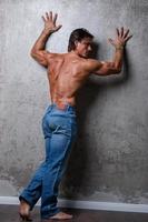 Portrait of Handsome muscle man wearing blue jeans photo