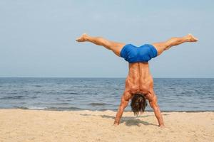 Muscular man during his workout on the beach photo