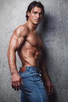 Portrait of Handsome muscle man wearing blue jeans photo