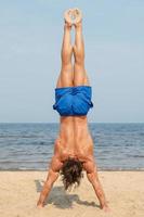 Muscular man during his workout on the beach photo