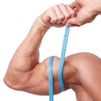 Closeup shot of Muscular man measuring his biceps photo