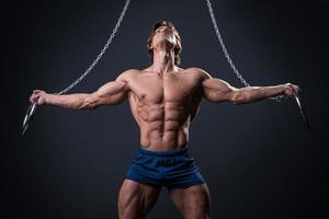 Strong muscular young gymnast guy and rings photo