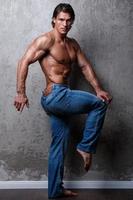 Portrait of Handsome muscle man wearing blue jeans photo