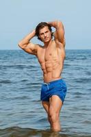 Muscular man during his workout on the beach photo