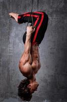 Muscular man during workout with suspension straps photo