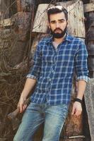 Handsome bearded man in checkered shirt with axe photo