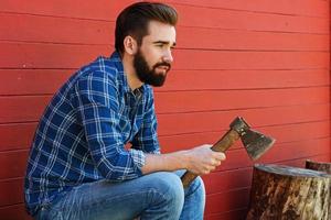 Handsome bearded man in checkered shirt with axe photo