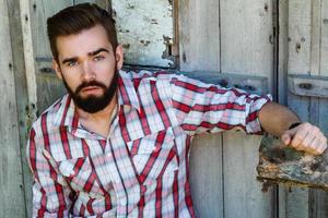 Handsome young bearded man in checkered shirt photo