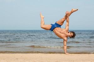 Muscular man during his workout on the beach photo