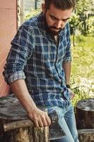 Handsome bearded man in checkered shirt with axe photo