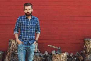 guapo hombre barbudo en camisa a cuadros con hacha foto