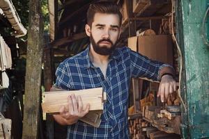 Handsome bearded young man with firewoods photo