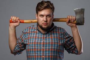 Bearded man with axe posing in studio photo