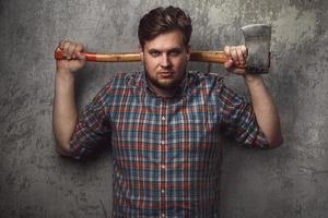 Bearded man with axe posing in studio photo