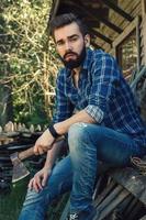 Handsome bearded man in checkered shirt with axe photo