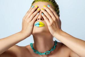 Beautiful woman with yellow hair and colorful nails and lips photo