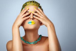 Beautiful woman with yellow hair and colorful nails and lips photo