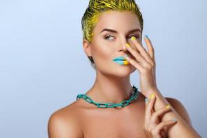 Beautiful woman with yellow hair and colorful nails and lips photo