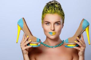 Beautiful woman with yellow holding colorful shoes photo