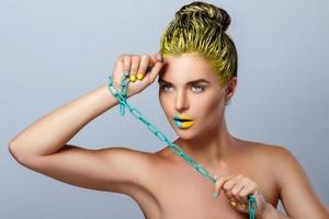 Beautiful woman with yellow hair and colorful nails and lips photo